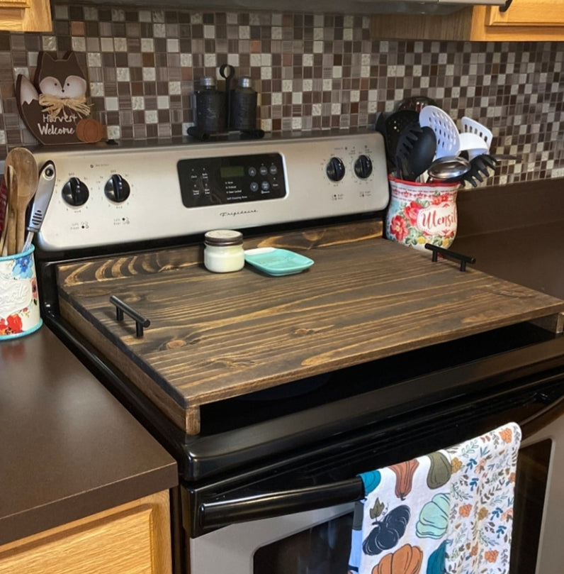 Handmade pine stove cover with tray-style handles on a kitchen stovetop