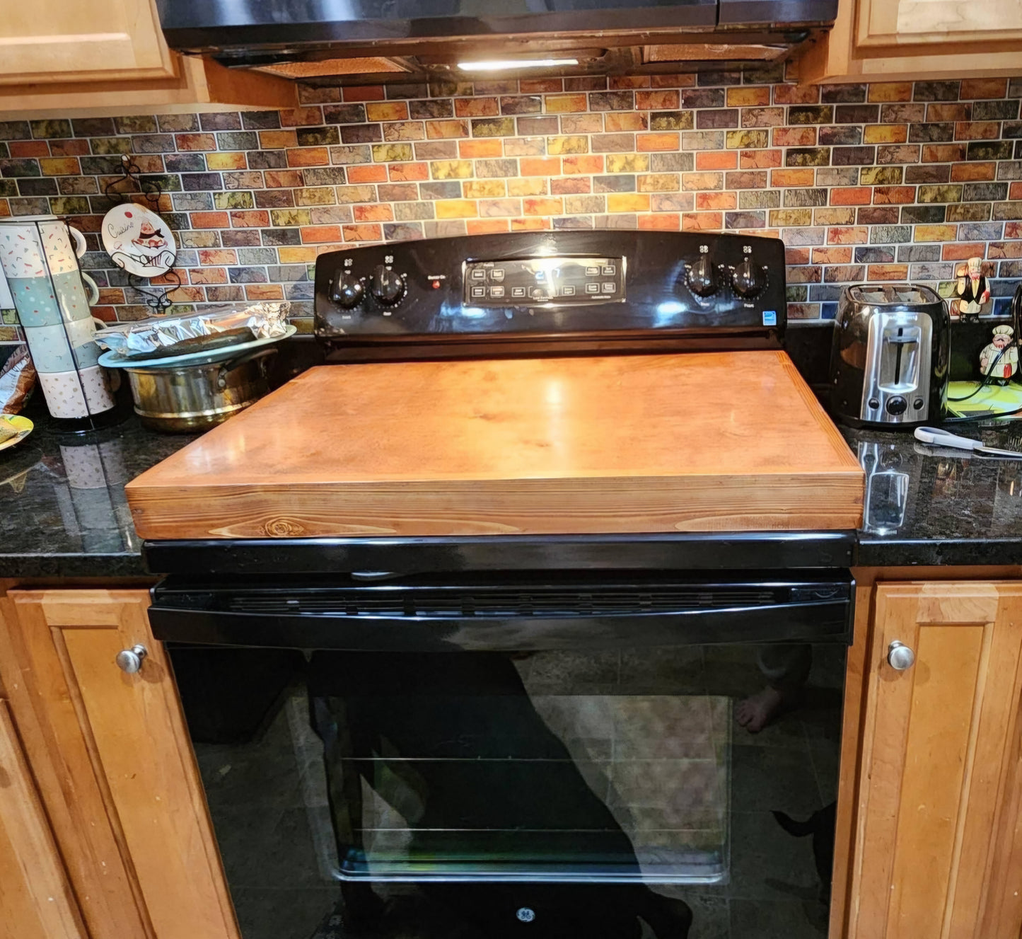 Handmade pine stove cover, box style, on a kitchen stovetop