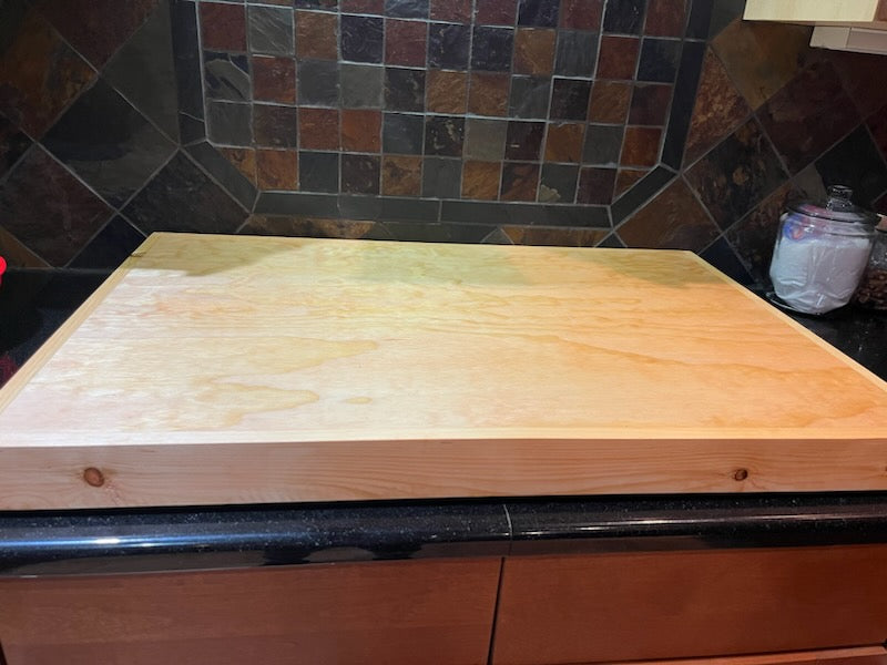 Handmade pine stove cover, box style, on a kitchen stovetop